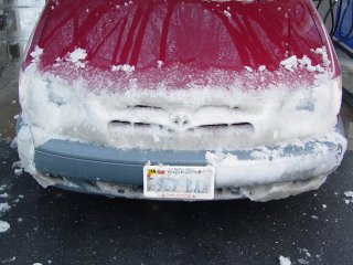 The front of our family's Toyota Sienna, covered in snow after driving through a snowstorm across four states.