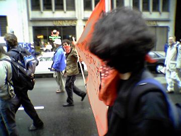 Masked protesters carrying a large red banner. They promoted the Web site redyouth.net.