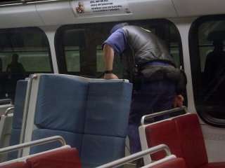 A man tinkers with things underneath the seat on Breda 3008.