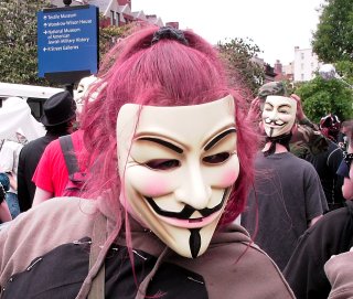 A woman wearing a Guy Fawkes mask