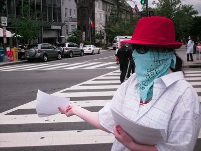 Handing out flyers on the street to passers-by.