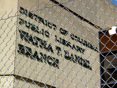 A chain-link fence surrounds the site of the Watha T. Daniel branch library in the Shaw neighborhood of Washington DC. The facility has been closed since 2004.