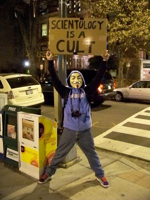 Anonsparrow, meanwhile, held a large, laminated sign saying, "SCIENTOLOGY IS A CULT", and Purple Hair Anon worked the cars.