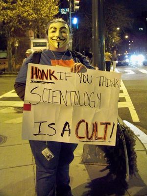 Anonsparrow, meanwhile, held a large, laminated sign saying, "SCIENTOLOGY IS A CULT", and Purple Hair Anon worked the cars.