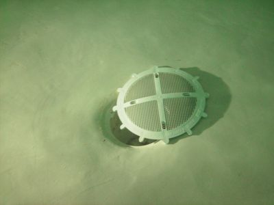 What you're looking at is one of the drain covers at the bottom of the pool, partially detached from where it should be. The weird lighting comes from the fact that the lights under the water were turned on. The photo amused me because it reminds me of those photos of the Titanic debris field, with an item of interest along this flat, featureless bottom.