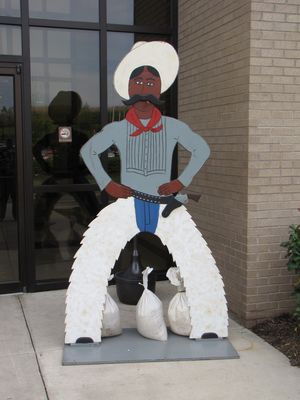 Wooden cowboy cutouts outside the shops building, welcoming people to the Rail Rodeo.