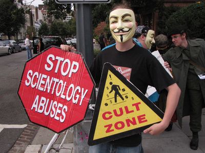 Our New York Anon holds up a sign done up to resemble a road sign.