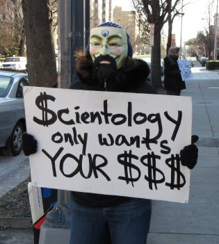 MaidofWin carries the "Scientology only wants your $$$" sign that we first made for Richmond.