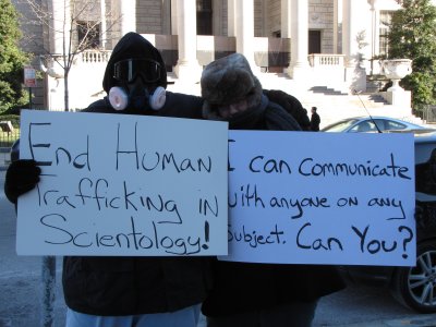 Meanwhile, HT and I pose with our signs. Mine says, "End human trafficking in Scientology!" while the other side of HT's sign says, "I can communicate with anyone on any subject. Can you?" Her sign refers to the fact that the Scientologists can't talk to us since we're all suppressive and such.