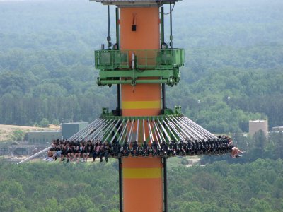 The drop tower drops a group, as seen from the Eiffel Tower.