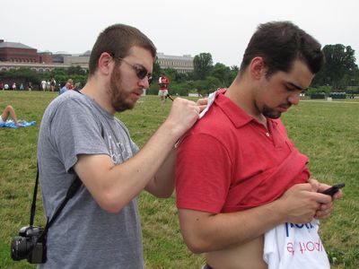 Jon signs an autograph, using Riley's shoulder as a surface to put the paper on.