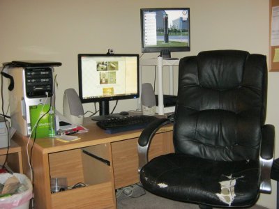 My computer workstation. This is where it all happens, folks. And my chair, almost eight years old now, looks every minute of it. The camera on top of the monitor is what I use to record Video Journals.