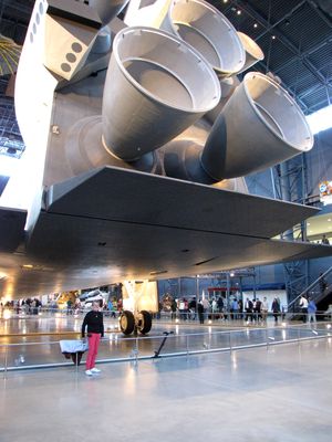 Mom stands under Enterprise's body flap, with the main engines in frame