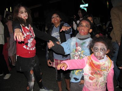 Four kids dressed as zombies. These four kids certainly knew how to ham it up for the camera, all right, however, the smallest one (wearing pink) didn't quite know how to handle photographers, in that she reached out and touched the camera.