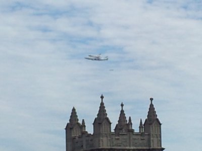 Discovery flies northeast of our position. The tower of Foundry United Methodist Church is visible in the bottom of the photo.