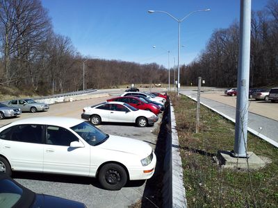 Looking east towards the physical end of the roadway. The intended eastbound lanes are to the right of the divider and the intended westbound lanes are to the left of the divider. I-70 traffic loops around the end of the roadway to switch from the eastbound side to the westbound side. The parking spaces are also accessed from the east end of the facility.