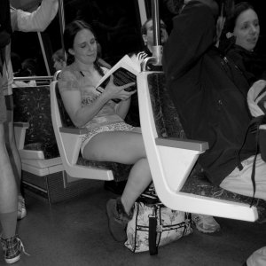 A woman reads a book while on Alstom 6027 (note the wool seat covers and gray floor).