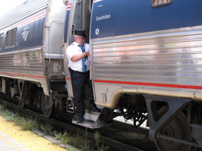 The conductor stands in the door as the train begins to leave Staunton Amtrak station.