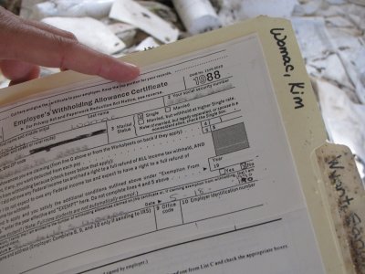 A completed Form W-4 for another employee, containing name, address, and social security number. A completed I-9 was attached to this form.