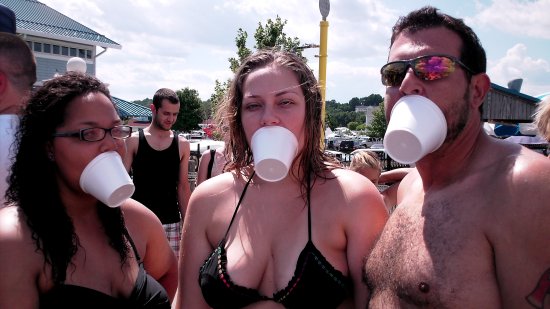 Doreen, Melissa, and Chris hold their cups on their faces using their mouths