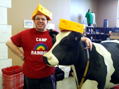 I pose with the cow, sporting a cheese hat