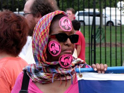 Wearing "Free Bradley Manning" stickers all over her face.