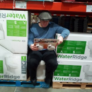 First of all, show of hands: who already knew that Costco sold toilets? That said, here I am, doing a fit test on said commode, complete with reading material.