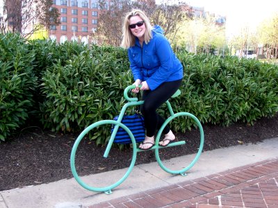 Melissa pretends to ride this metal bicycle sculpture.