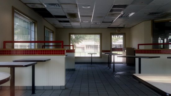 Dining room, from the opposite side of the building. Since closing, the building has apparently experienced some water leakage, since a number of the ceiling tiles are noticeably sagging, and some have visible mold on them.