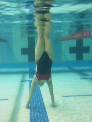 Suzie does a handstand on the bottom of the pool.