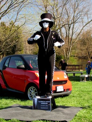 While not a car, this person's "robotic mime" performance was quite impressive to watch.  This person would stand motionless for several minutes, and then change position in a way that made the movement appear mechanical in origin rather than being done by a living being.  They have a website, humanimate.com, where there are photos and videos of other performances, as well as a description of what robotic mime is.