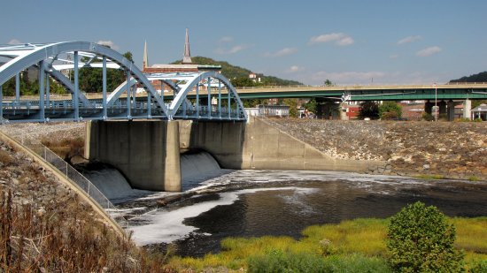 The bridge from Cumberland to Ridgeley, and the area of the Potomac River immediately downstream from it. There is a waterfall, presumably manmade, directly beneath the bridge.