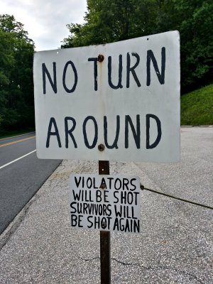 "NO TURN AROUND. VIOLATORS WILL BE SHOT. SURVIVORS WILL BE SHOT AGAIN."