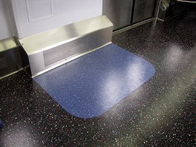 The floor is not carpeted and primarily black, with red, white, and blue flecks in it for a slightly patriotic touch.  The designated wheelchair area next to the center doors, similar in size to the 6000-Series cars, is marked out on the floor in blue.