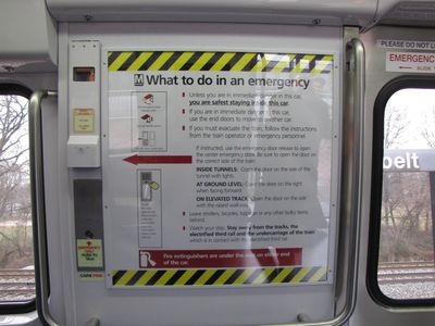 Emergency instructions, door release handle, and center intercom.  This version of the evacuation sign is completely new, and unlike past versions, has no system map.