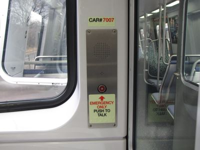 The emergency intercoms, shown here at the coupler end of car 7007, are now steel rather than plastic.  The red button now has a light in the center of it.  The car number is located adjacent to the intercom unit.