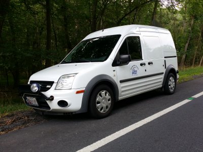 White Ford Transit Connect van with "Safe Speed" on the door