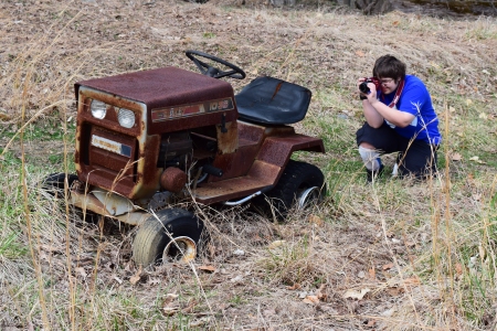 Elyse photographs a Sears Craftsman ride on lawnmower in the front yard.