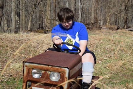 Elyse pretends to ride the lawnmower. I caption this as, "Why... won't... you... start?"