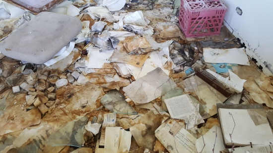 Documents scattered all over the floor, in noticeably worse condition than 2013