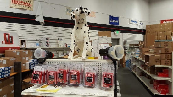 Display of Fire-Lite BG-12s, complete with large stuffed dalmatian. The dalmatian is Fire-Lite's mascot.