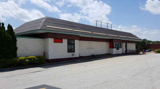 Exterior, with new roof going on, covering the double mansard that the facility had when it was still in operation. Also note the McDonald's labelscar on the side of the building. Guessing that they paint the exterior in order to hide these labelscar markings.