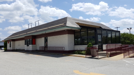 Exterior, with new roof going on, covering the double mansard that the facility had when it was still in operation. Also note the McDonald's labelscar on the side of the building. Guessing that they paint the exterior in order to hide these labelscar markings.