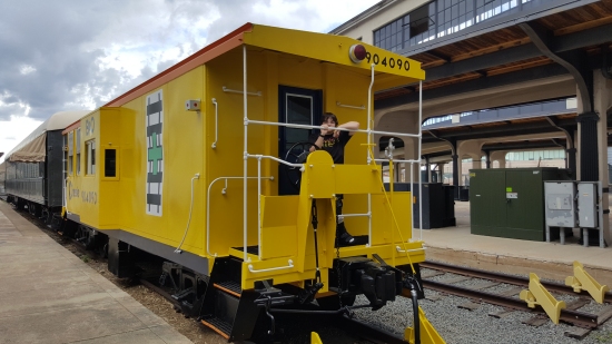 Elyse poses with the caboose on display