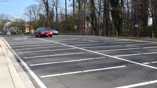 Approach to the crossing for westbound traffic.  Lots of lines on the road in approach to the crosswalk.