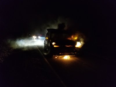 The early stages of the fire, at 10:45 PM.  Note that the lights are still on, and flame is visible coming out from under the hood, through the grille, and underneath.