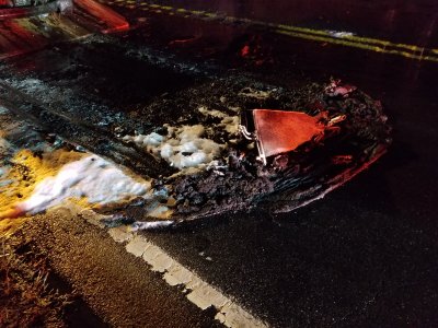 Debris that melted off of the front of the car.  This is the front bumper, the grille, the headlights, and various other things.  Pretty sure that the front license plate was in there as well.  You can see part of the radiator sitting on top.