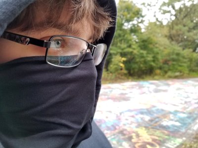 Elyse wears a black bandanna as a filter for spray paint fumes while she was tagging.  I put her in all black for the planned photo set, but the bandanna was her own idea.  I laughed, because Elyse was dressed in "full black bloc" for the purpose of tagging the abandoned road.