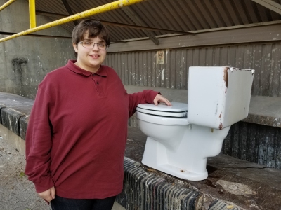 Elyse poses for one final photo with the old commode at the Shady Grove Transfer Station.