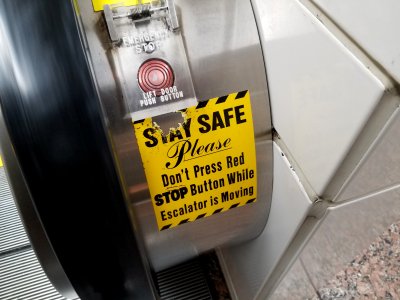 "Stay Safe: Please don't press red STOP button while escalator is moving"